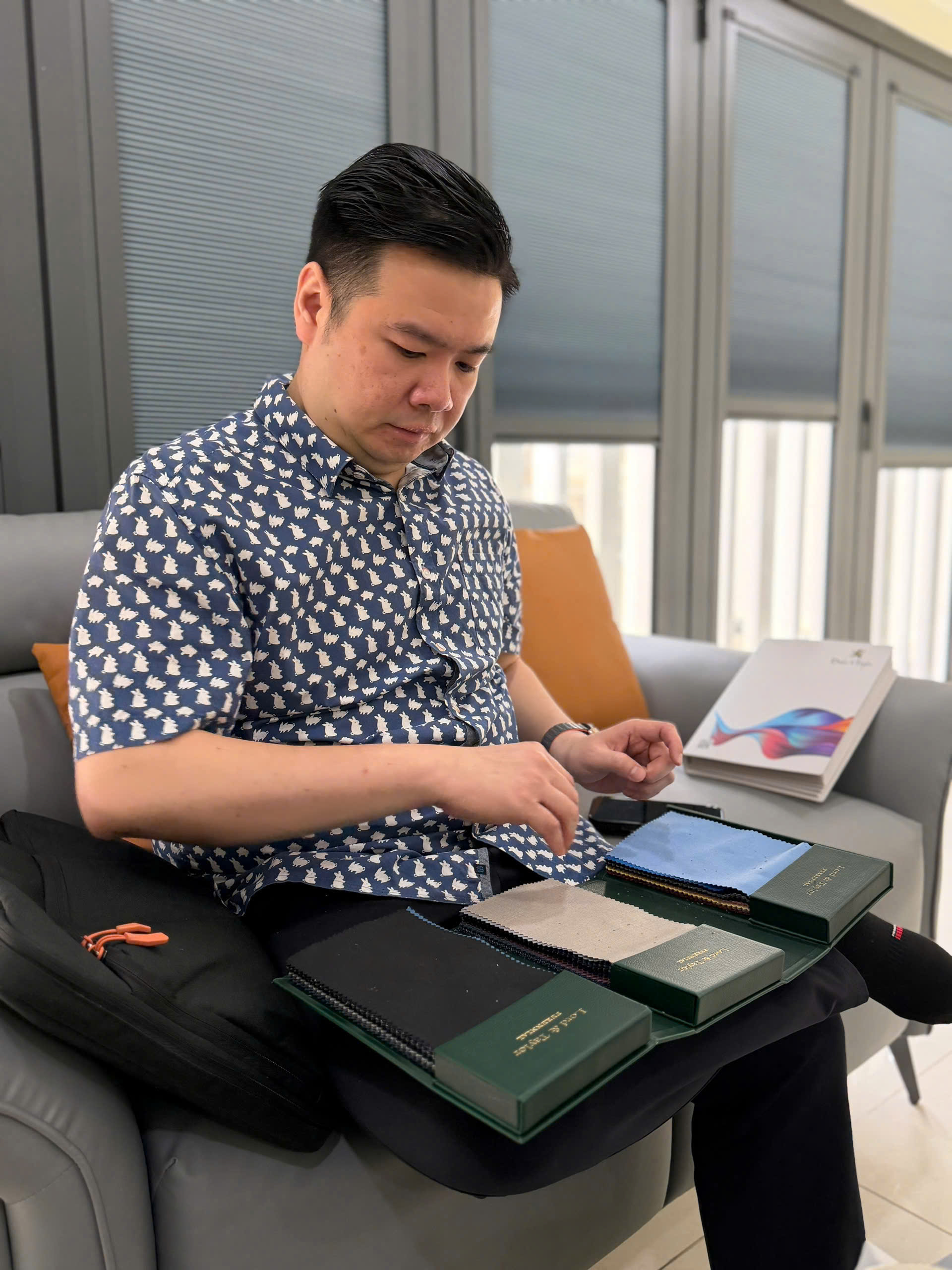 Chee Wee inspecting fabric samples at a Vietnam textile mill